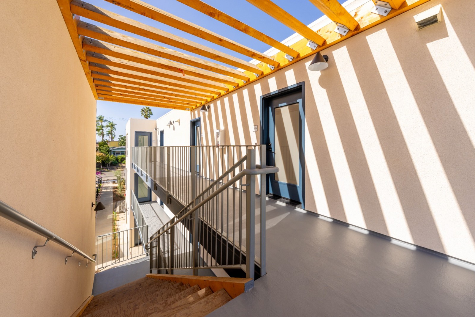 Upper walkway, stairs and wood pergola at Florida Street Micro Units